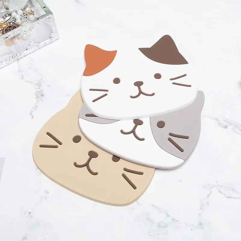Calico, tabby and grey-and-white cat coasters fanned out on a marble surface