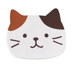 Calico cat coaster close up: white with one orange ear and one brown ear