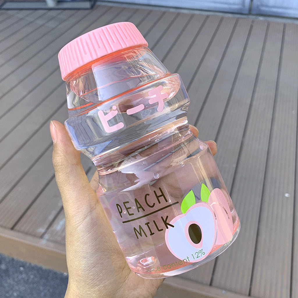 Clear peach fruit milk water bottle held in one hand to show its size