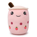 Boba Plush Pillow in pink with open eyes, a plush bubble-tea cup with a cream lid, straw, pearls and strawberry prints, on a white background