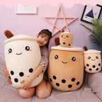 Model seated with a white and a brown Boba Plush Pillow on a bed