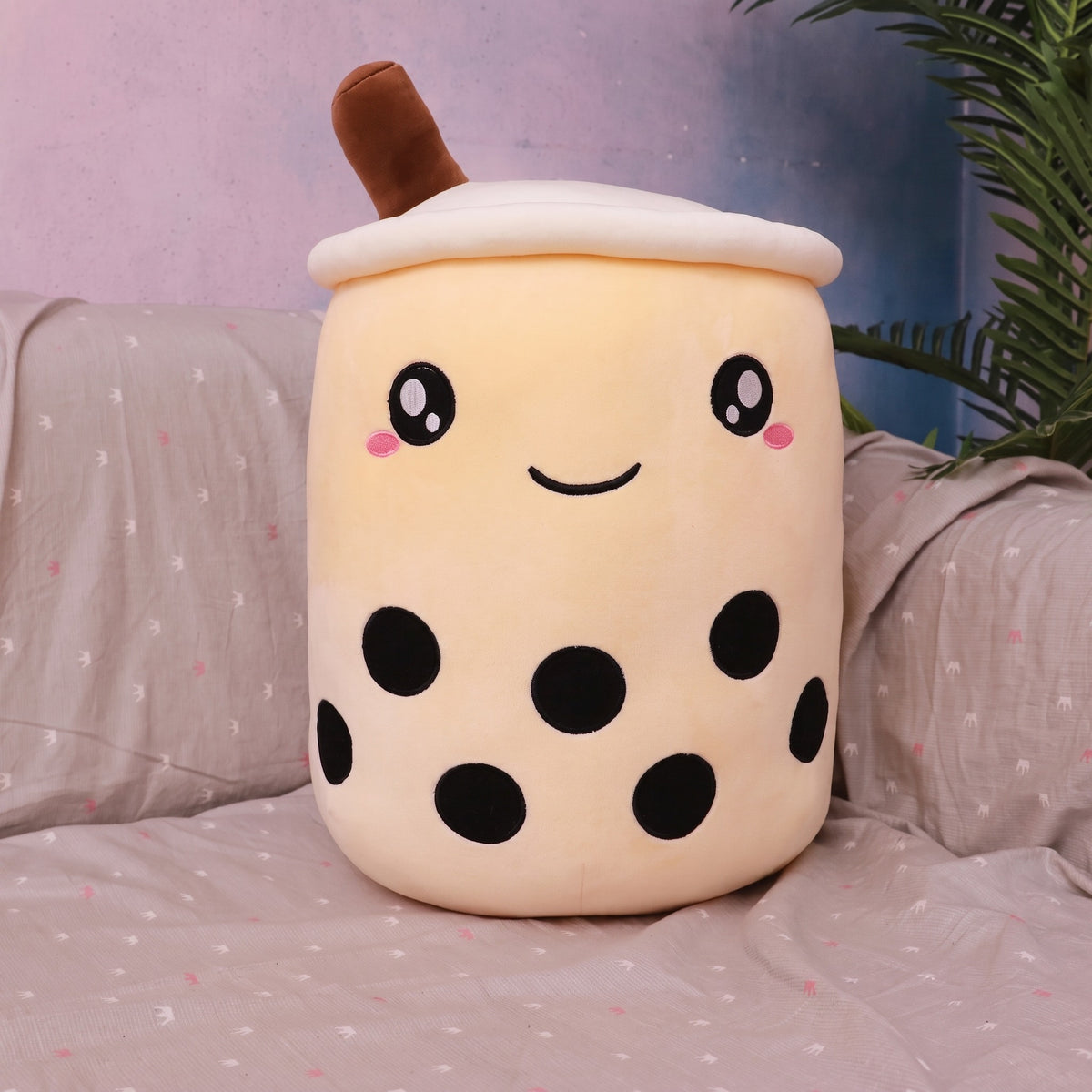 Boba Plush Pillow in beige, wide open eyes and blushing cheeks, a plush bubble-tea cup with a cream lid, straw and pearls