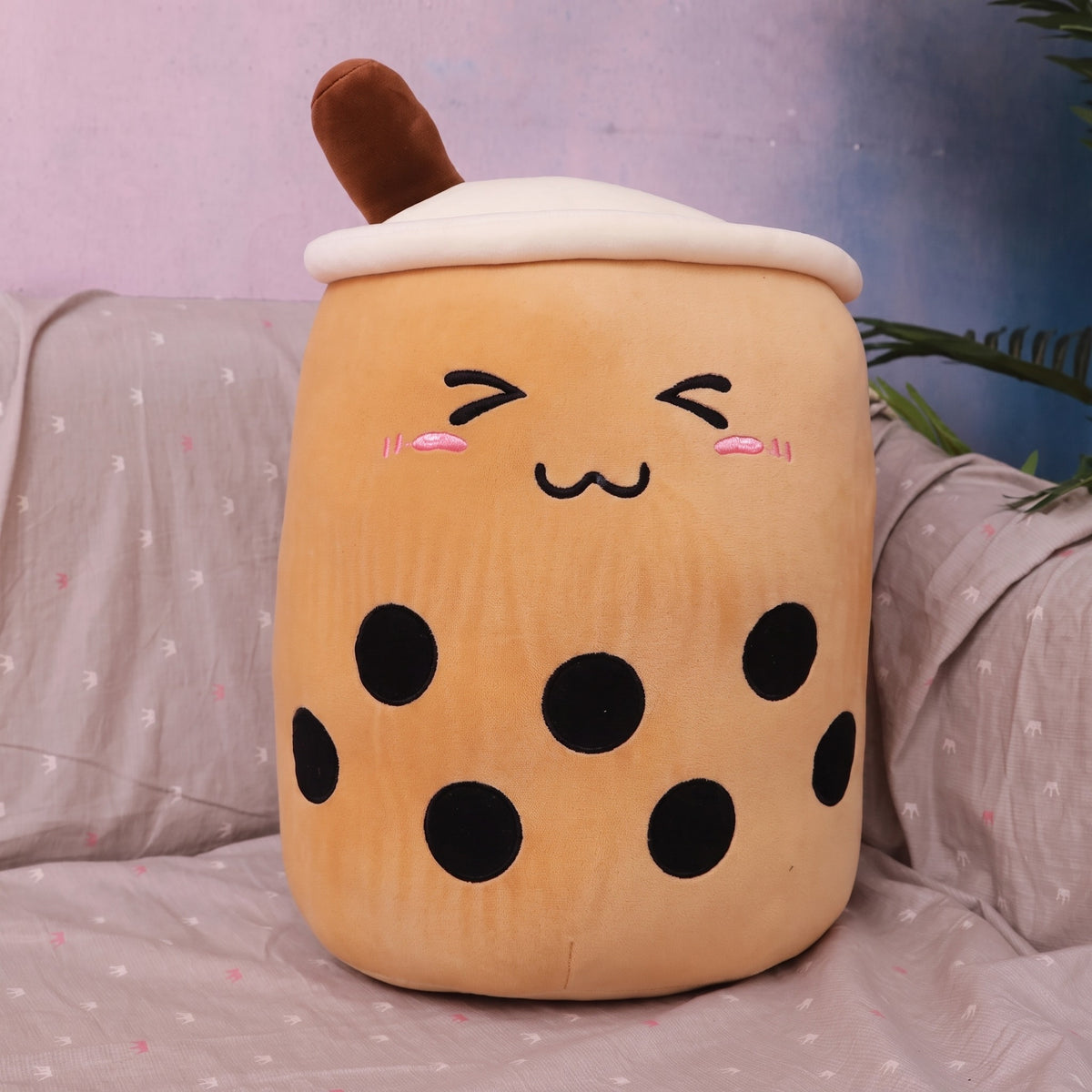 Boba Plush Pillow in milk-tea brown, closed happy eyes and blushing cheeks, a plush bubble-tea cup with a cream lid, straw and pearls