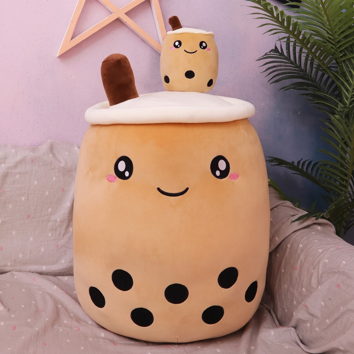 Boba Plush Pillow in milk-tea brown, wide open eyes and blushing cheeks, a plush bubble-tea cup with a cream lid, straw and pearls