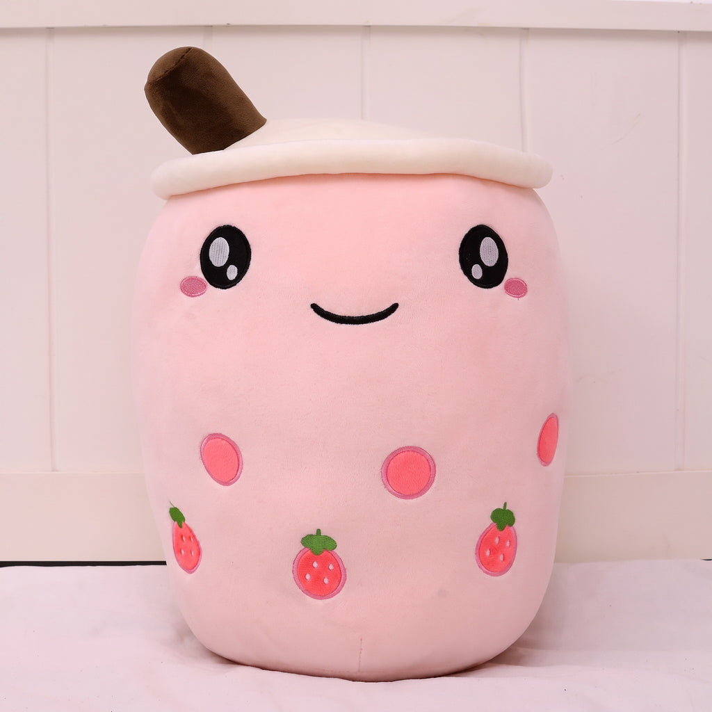 Boba Plush Pillow in pink with strawberry prints, wide open eyes and blushing cheeks, a plush bubble-tea cup with a cream lid, straw and pearls