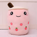 Boba Plush Pillow in pink with strawberry prints, wide open eyes and blushing cheeks, a plush bubble-tea cup with a cream lid, straw and pearls