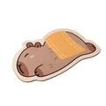 Capybara Bath Mat, Towel Wrap design, on white seen from above: a mat cut around a cartoon capybara lying on its back under a folded orange towel
