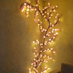 Pink Cherry Blossom Branch Light lit on a warm-toned wall