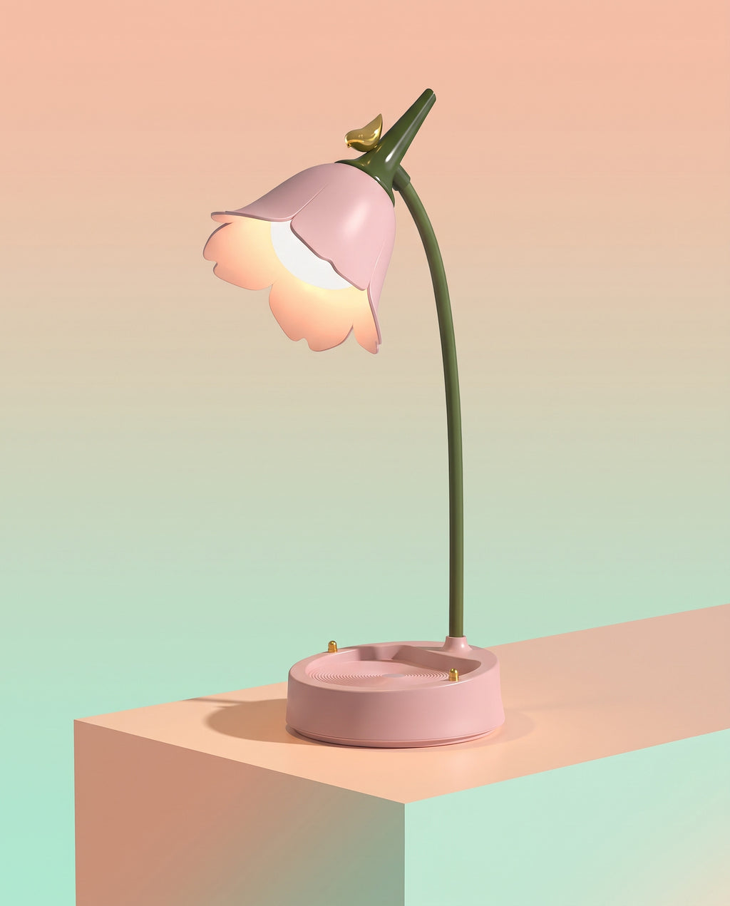 Flower LED Desk Lamp in pink, lit warm, on a peach block against a pastel gradient