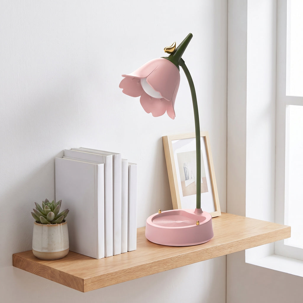 Flower LED Desk Lamp in pink, switched off, on a wall shelf with books and a small plant