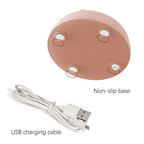 Underside of the lamp base showing four non-slip pads, next to the included USB charging cable