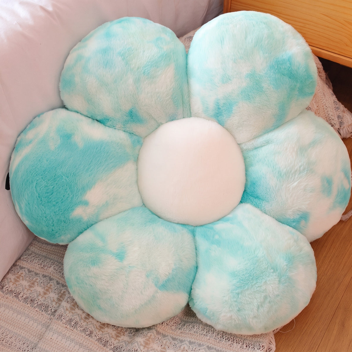 Flower Plush Pillow in fluffy aqua tie-dye, six plush petals, on a bed