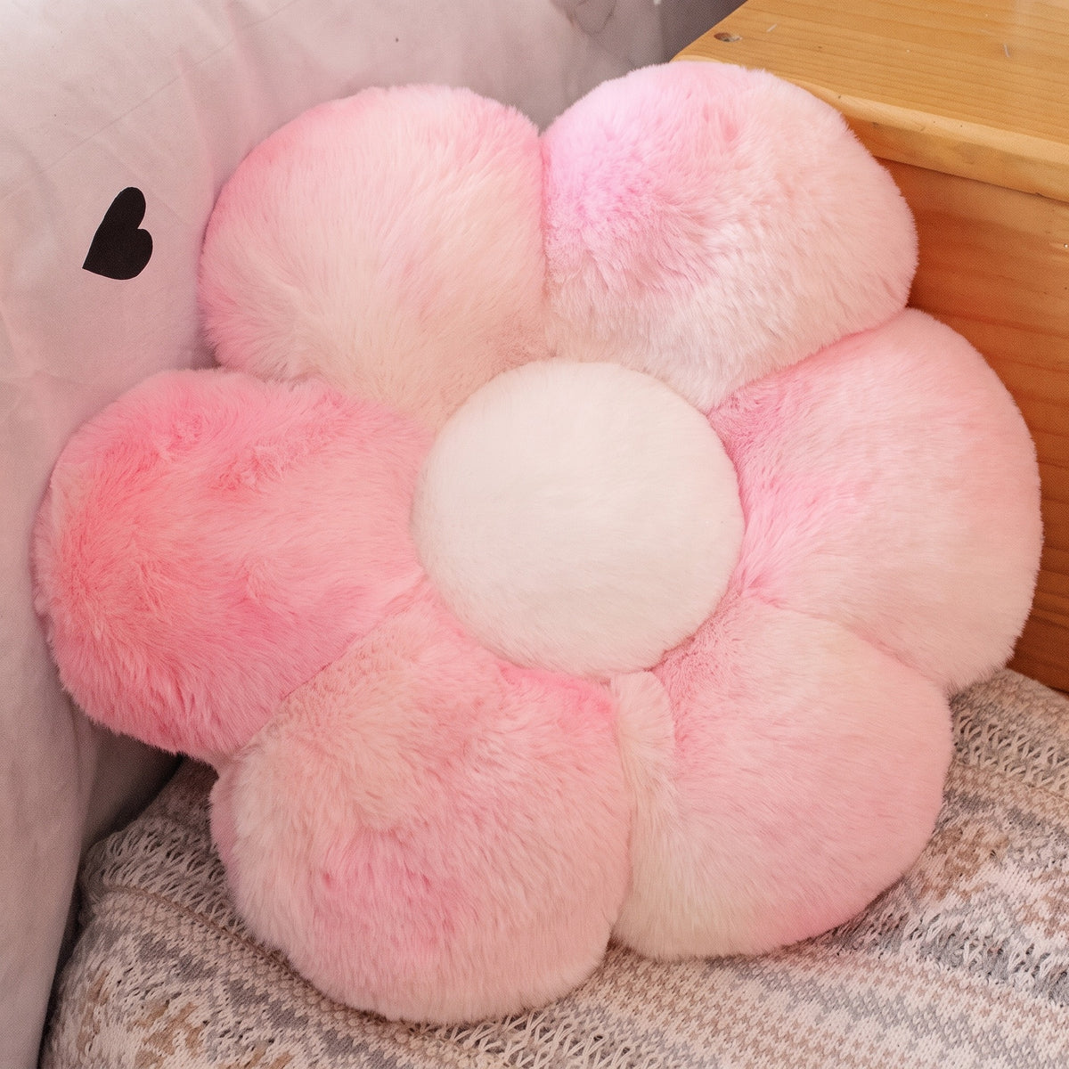 Flower Plush Pillow in fluffy pink tie-dye, six plush petals, on a bed