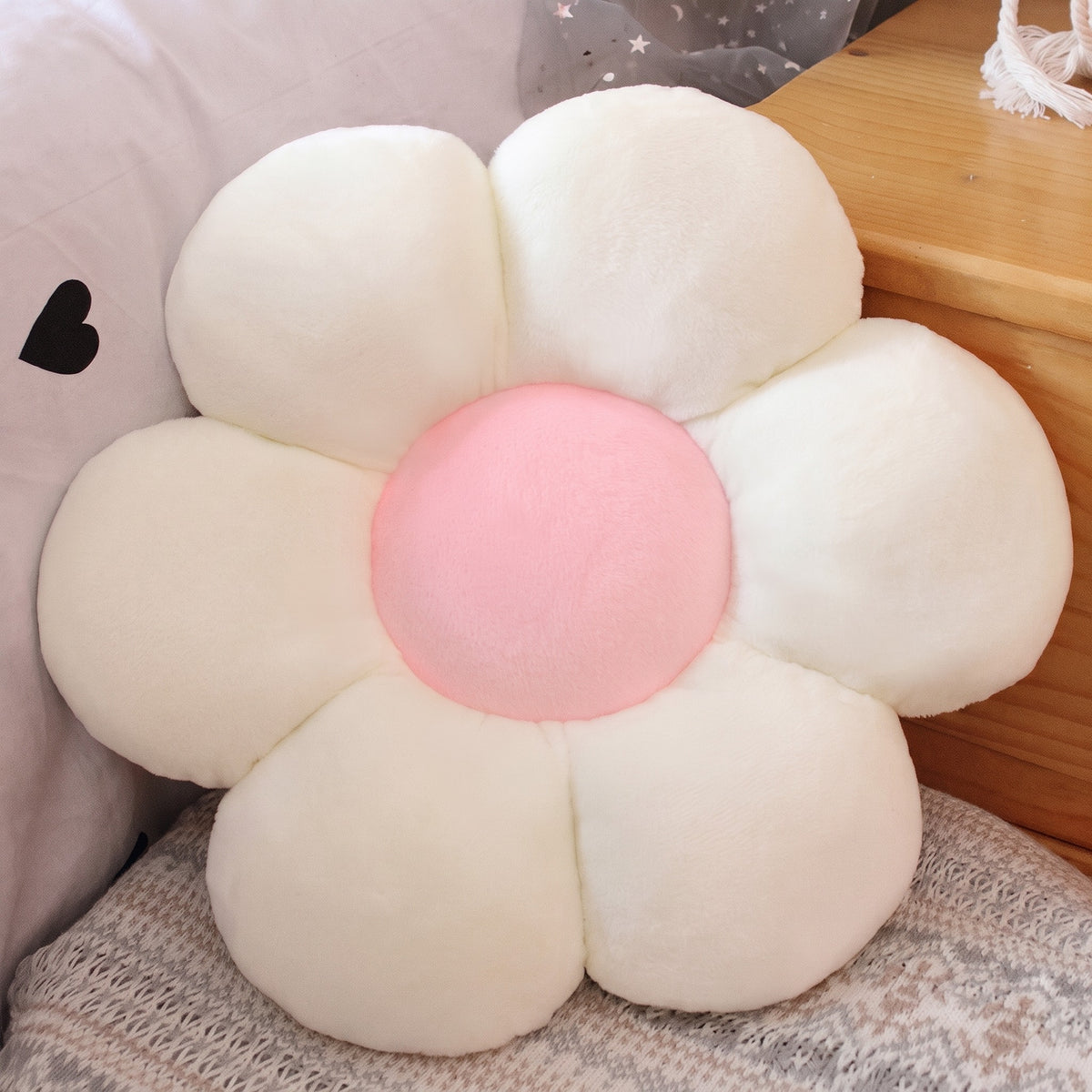 Flower Plush Pillow in white with a pink center, six plush petals, on a bed
