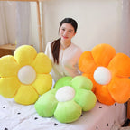 Yellow, orange and light green Flower Plush Pillows on a bed, with a model