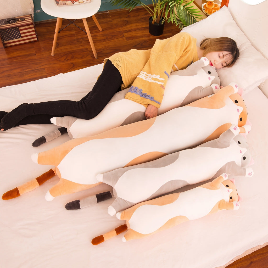 Woman lying on a bed with three Long Cat Plush Pillows