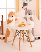 Orange Long Cat Plush Pillow standing beside a small round table