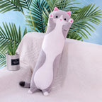 Long Cat Plush Pillow in grey, a slim plush cat with a white belly and raised paws, standing on a sofa
