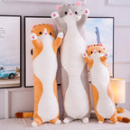 Long Cat Plush Pillows in orange and grey, three lengths standing in a living room