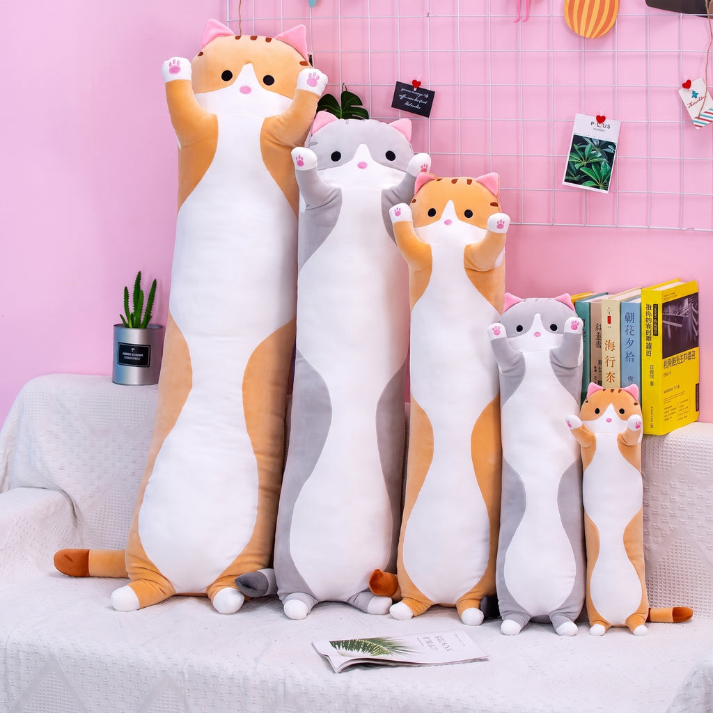 Long Cat Plush Pillows in orange and grey, three lengths against a pink wall