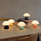 Five mini mushroom lamps lit on a table
