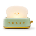 Toaster Night Light in mint, a small toaster with a glowing slice of toast, switched on, on a white background