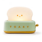 Toaster Night Light in mint, a small toaster with a glowing slice of toast, switched on, on a white background