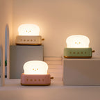 Toaster Night Lights in cream, mint and pink, lit, on pale display blocks